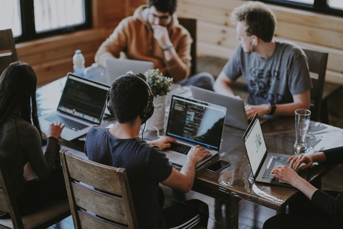 A cross-functional team collaborating on laptops